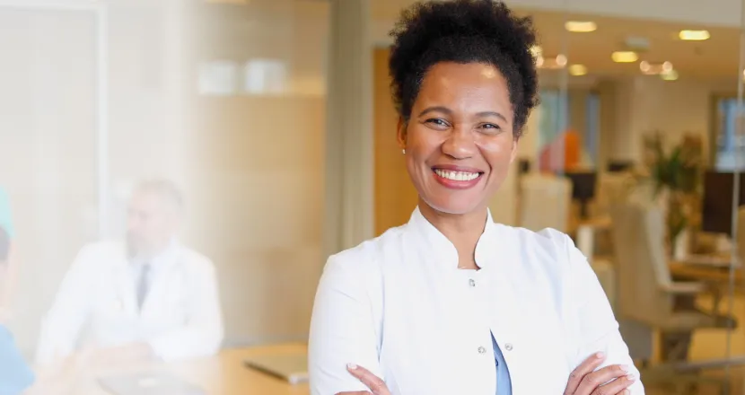 DNP nurse executive smiling in conference room during team meeting