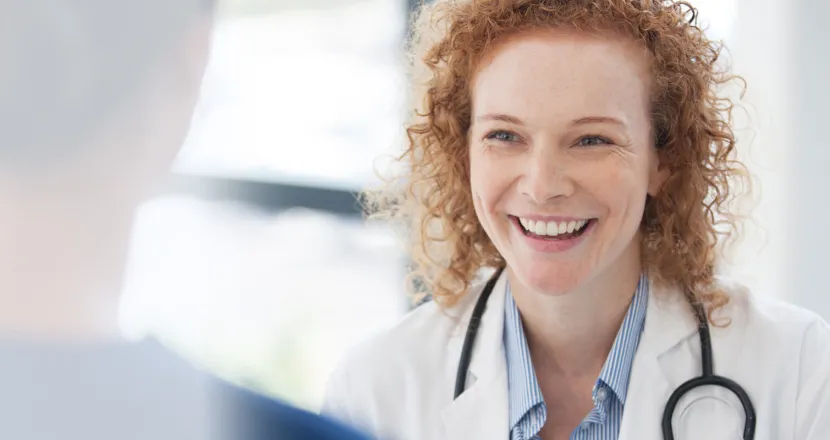 Public health nurse with DNP smiling with RN in hospital