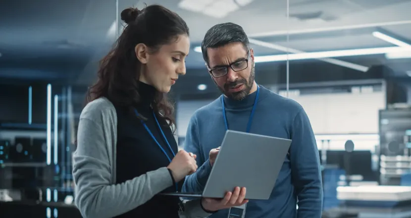 Team of cybersecurity professionals reviewing security implementation on laptop