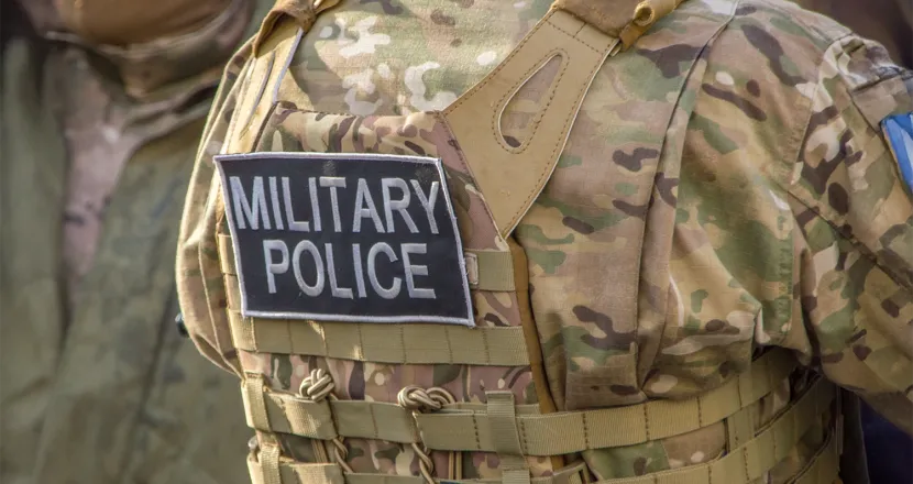 Close-up of a military police officer’s tactical vest with a ‘MILITARY POLICE’ patch, representing law enforcement within the armed forces.