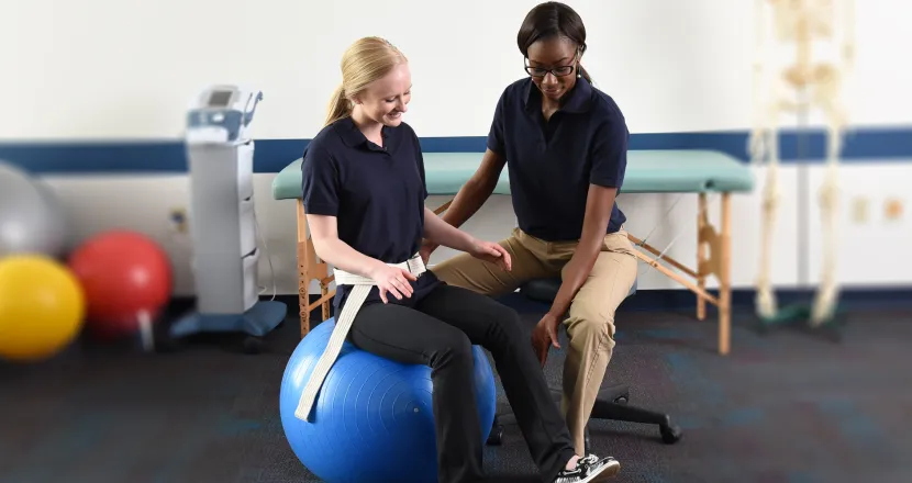 Physical therapist assistant helping patient to stretch