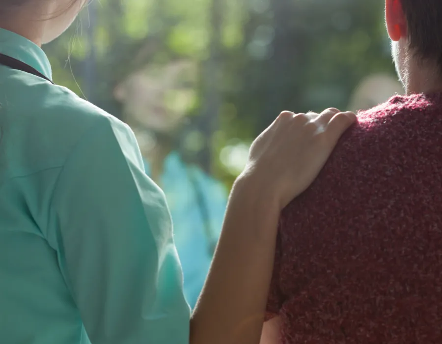 Psychiatric-Mental Health Nurse Practitioner PMHNP placing hand on patient's shoulder giving comfort