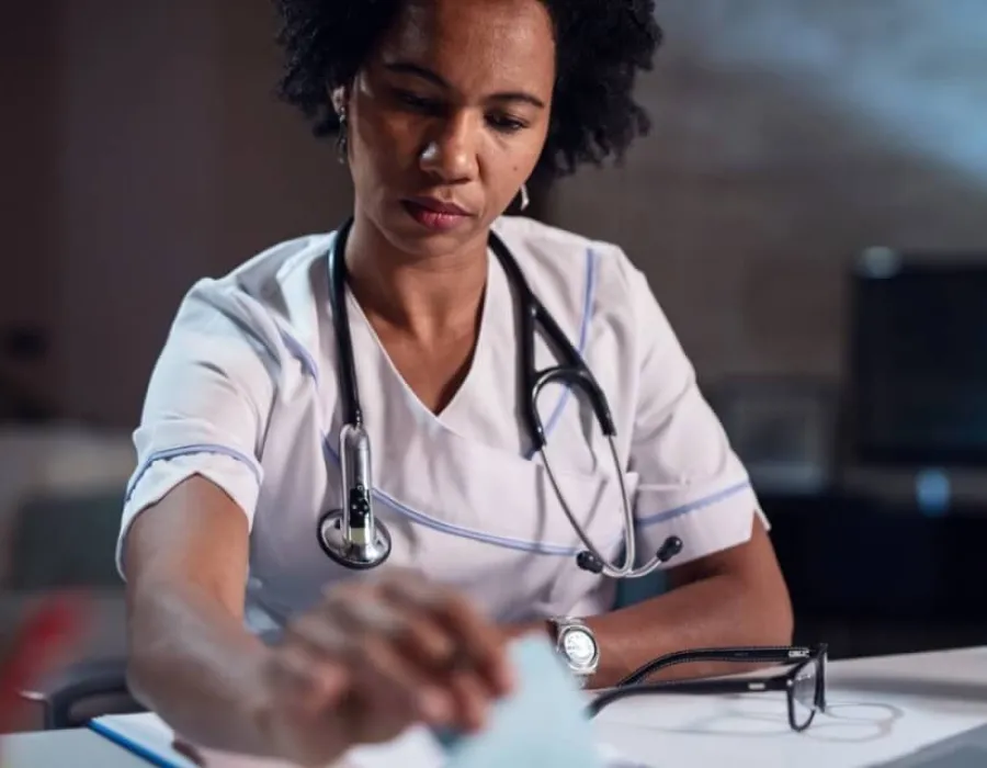 Nurse with associate degree in nursing reviewing documents in office