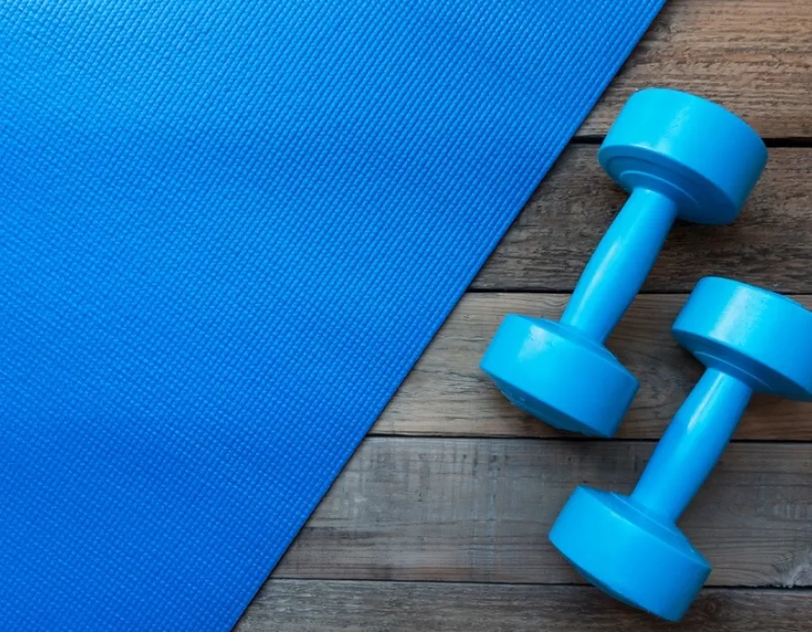 Dumbbells and yoga mat resting on floor of exercise room for PTA