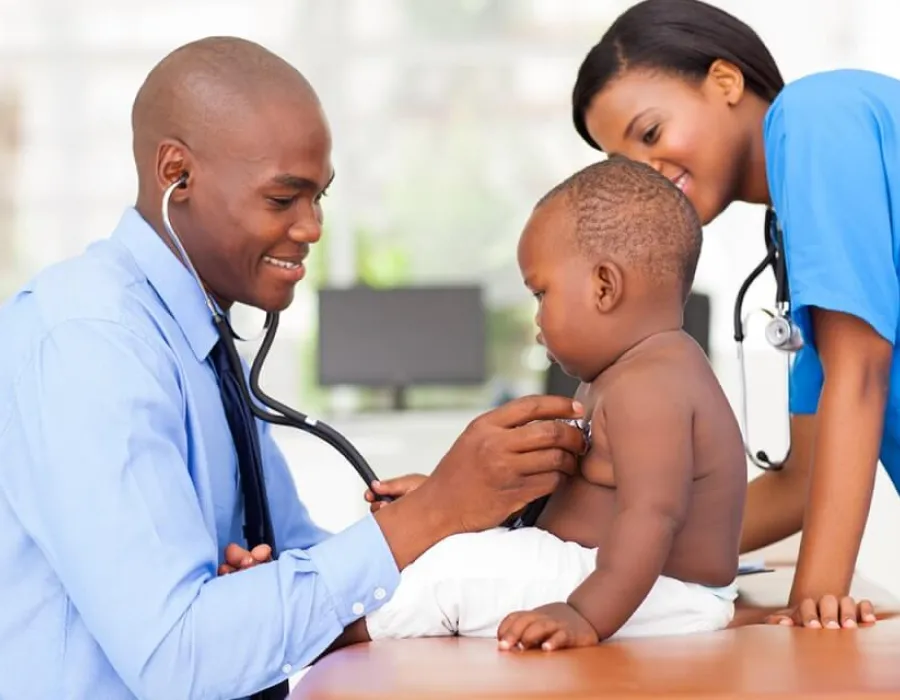 Family nurse practitioner working with nurse to take heart rate of pediatric patient