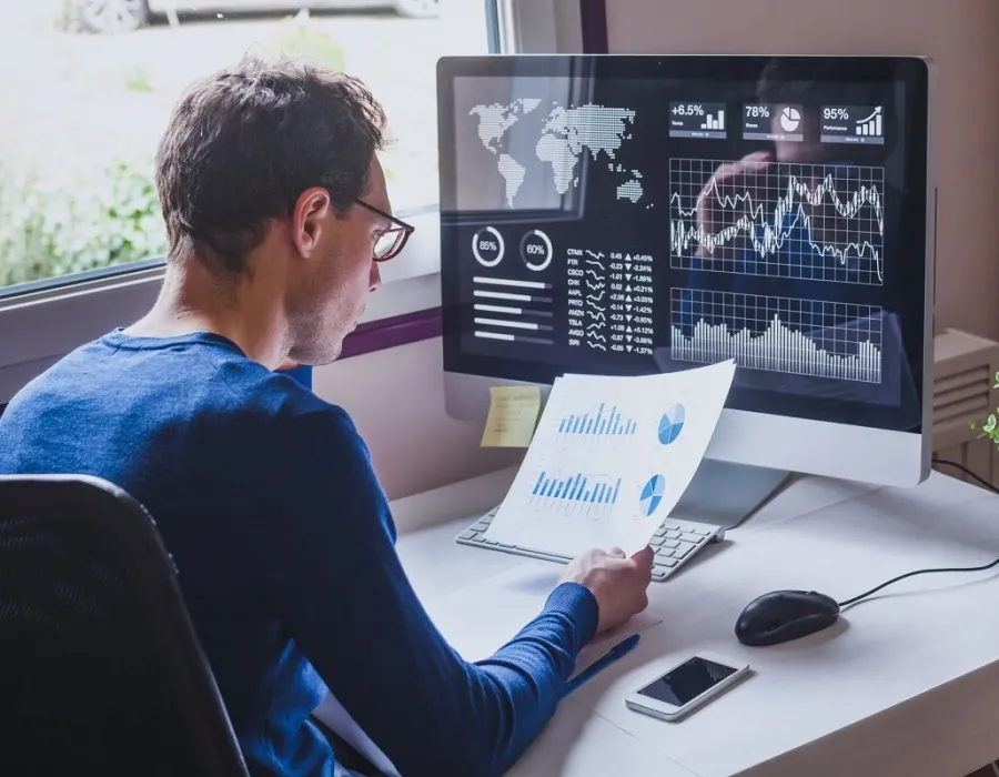 Data analyst seated at desk reviewing performance metrics