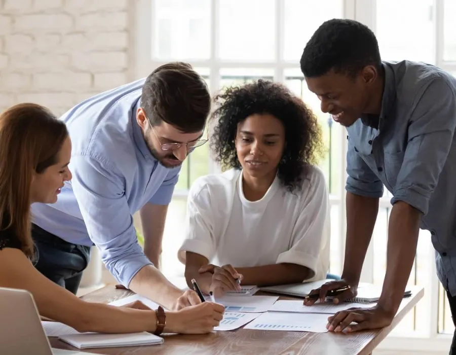 Three HR managers reviewing documents in team meeting