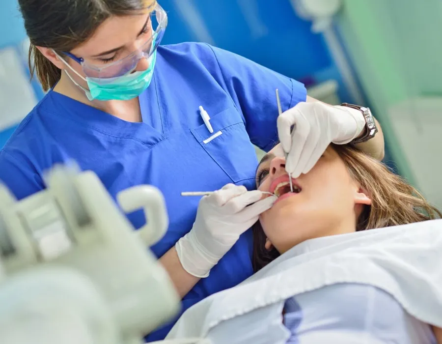 Dental Hygienist in Dentist Office Cleaning Teeth