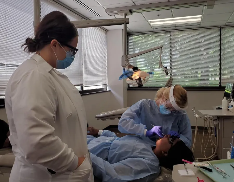 Dental Assistant in Dental Hygienist School Practicing Cleaning Patient Teeth