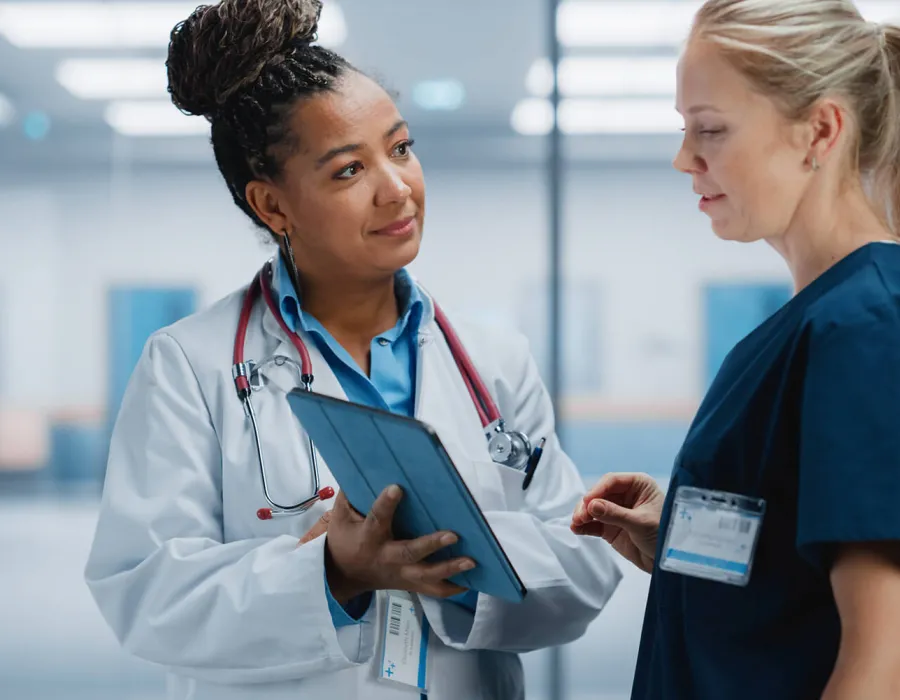 Nurse Practitioner Showing Patient Chart to Registered Nurse