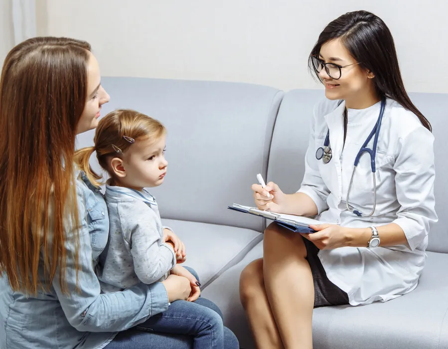 Pediatric Nurse Practitioner Smiling with Patient in Exam