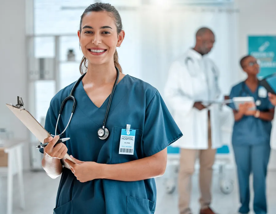 Nurse in Green Scrubs Smiling While Holding Clipboard