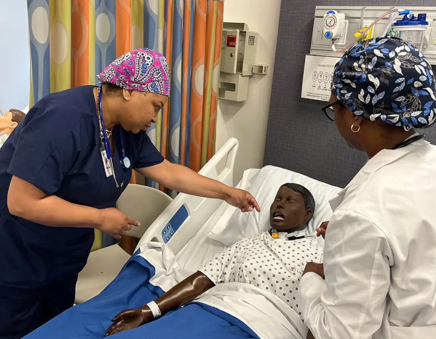 Undergraduate nursing student practicing on dummy during on-campus simulation experience