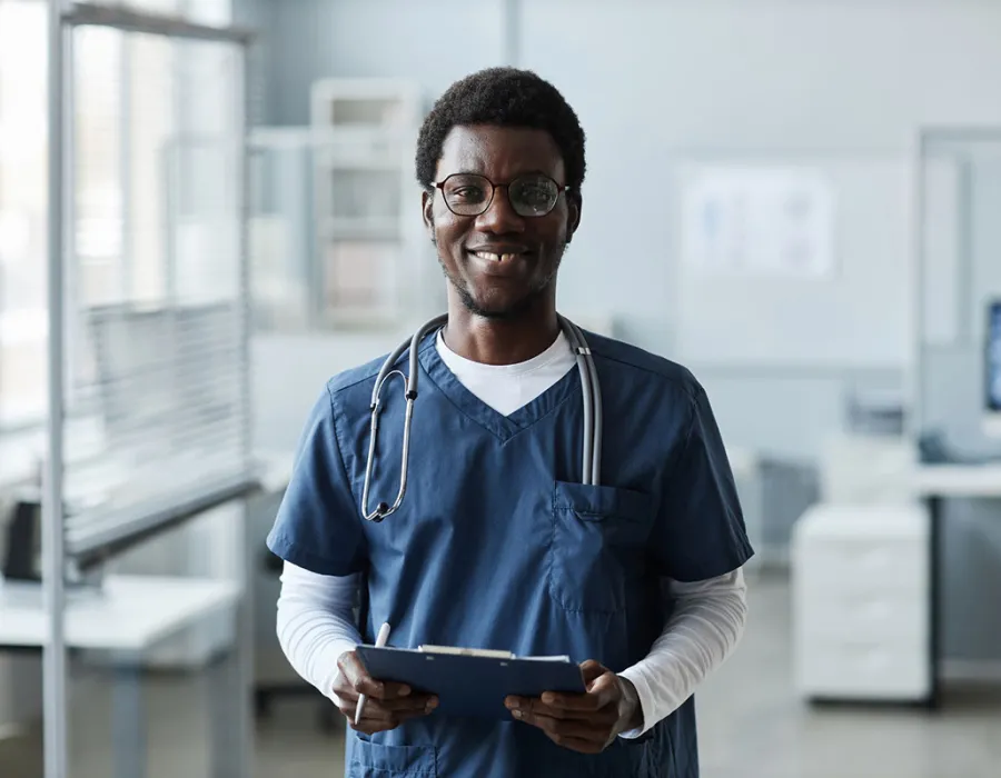 Medical assistant holding clipboard in physician's office