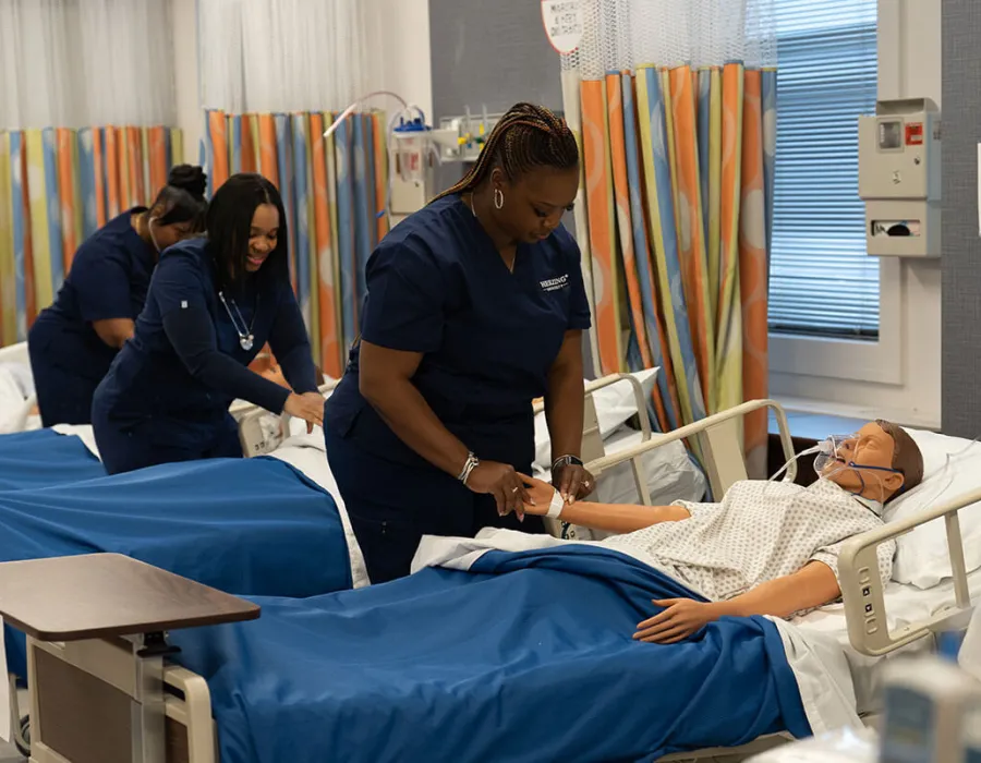 Herzing online nursing students training on mannequins during intensive experience