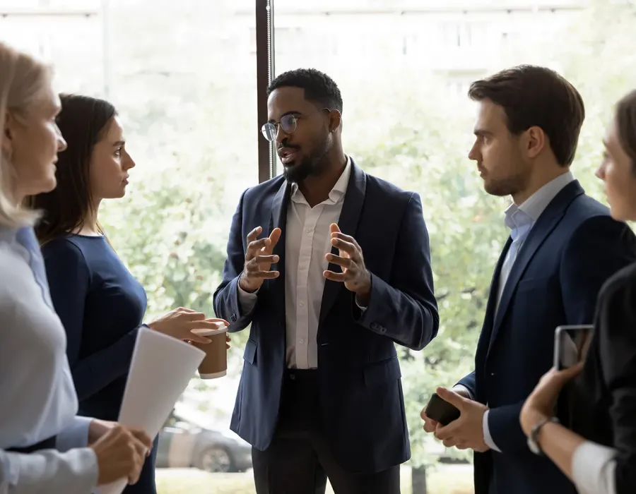 Business manager discussing strategy with team members in well lit office