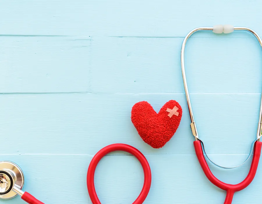 Red stethoscope rested upon a painted blue wood slat floor