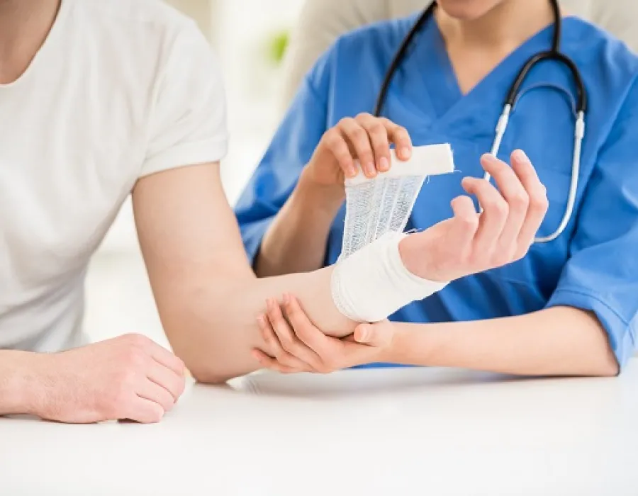 Wound care nurse applying gauze wrap to patient