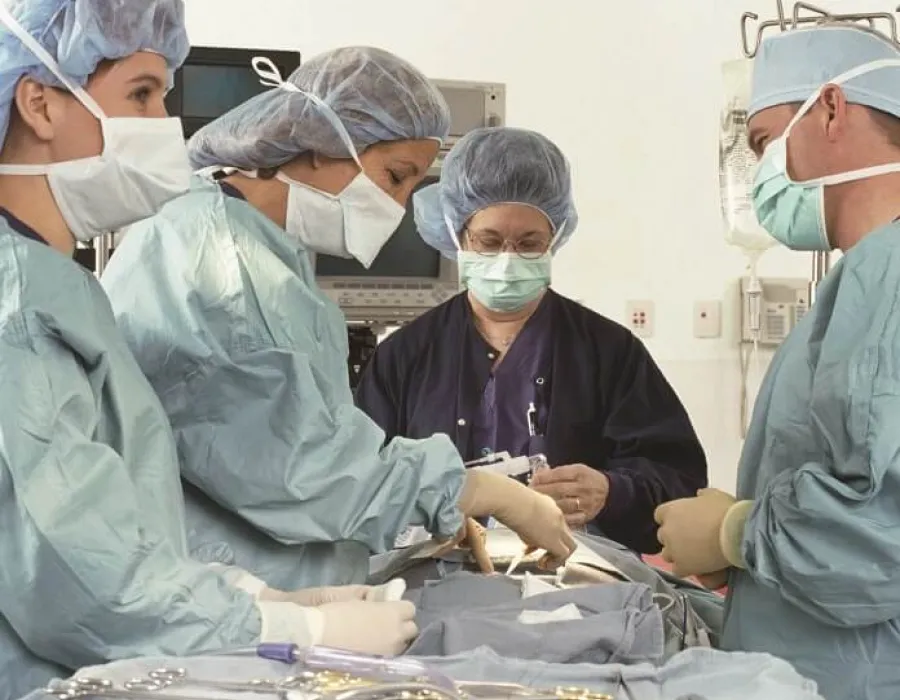 Nurse anesthetist assisting surgical team in advance of procedure