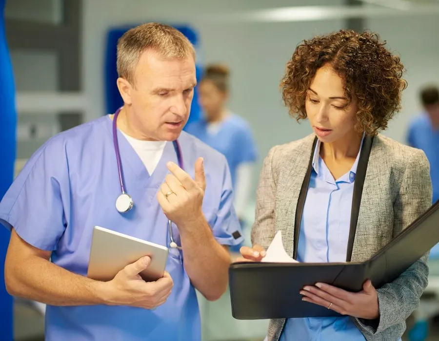 Nursing administrator reviewing patient diagnosis and treatment with registered nurse