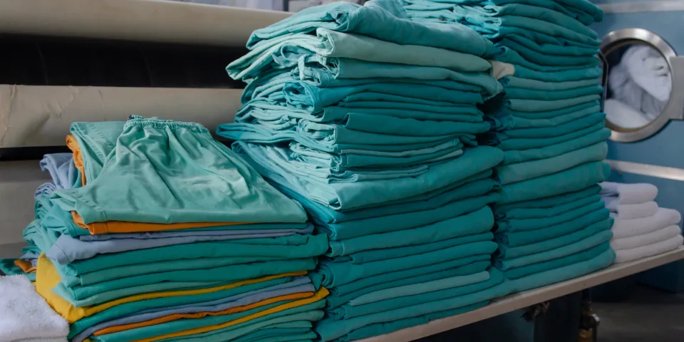 Stack of modern day green scrubs neatly folded in a pile