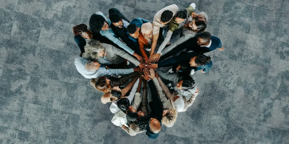 A diverse business group standing in a heart formation, symbolizing unity, teamwork, and collaboration.