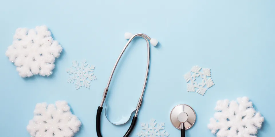 blue background with stethoscope and snowflakes, medical winter holiday. copy space