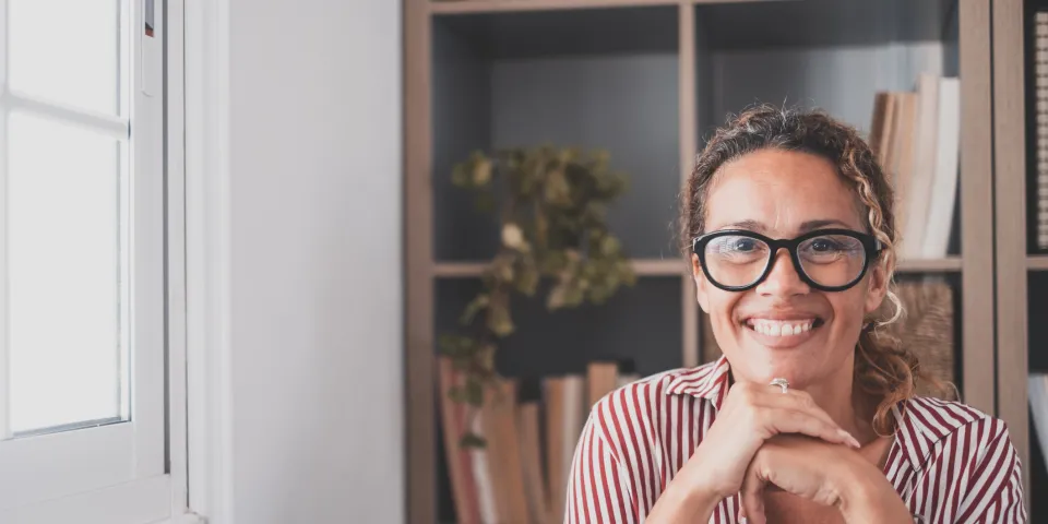 Portrait of one young and happy cheerful woman smiling looking at the camera having fun. Headshot of female person working at home in the office.