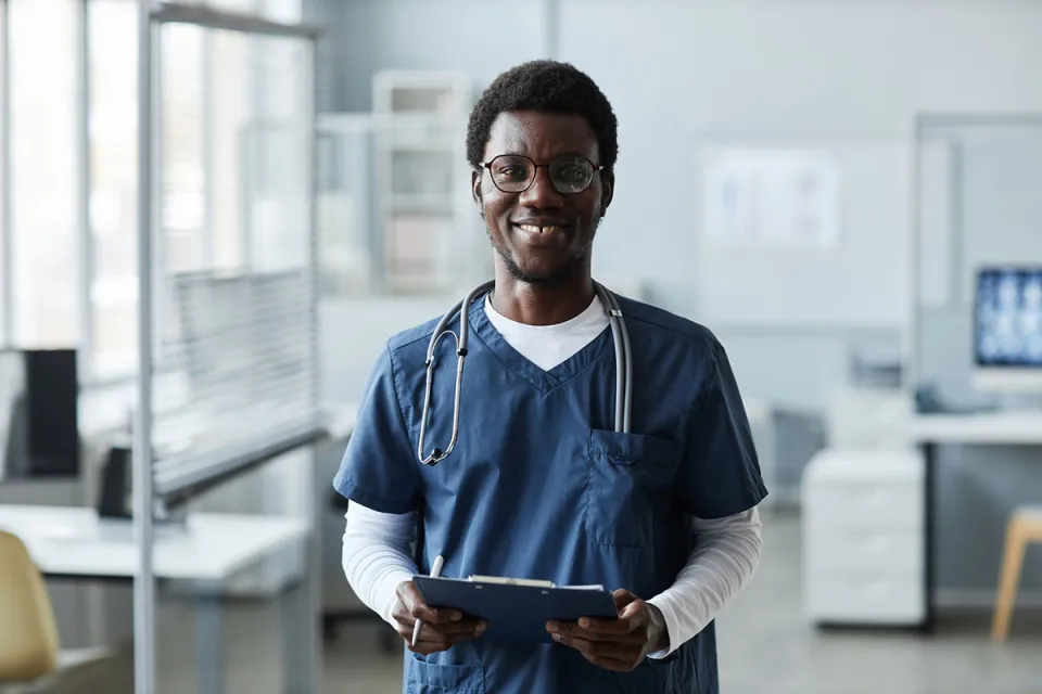 Medical assistant holding clipboard in physician's office