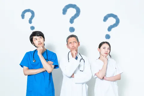 Three medical professionals deep in thought with question marks over their heads