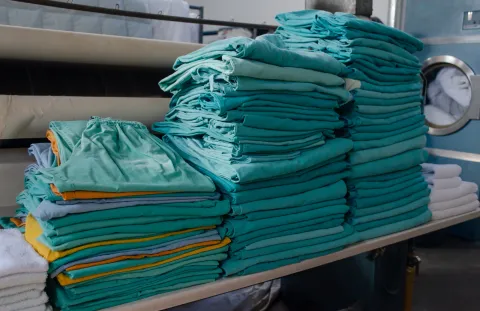 Stack of modern day green scrubs neatly folded in a pile